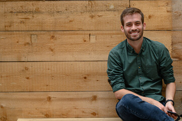 Summer portrait of a man in a wooden background in summer