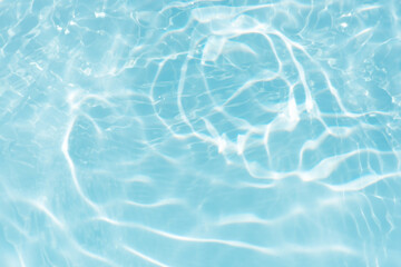 Blue water with ripples on the surface. Defocus blurred transparent blue colored clear calm water surface texture with splashes and bubbles. Water waves with shining pattern texture background.