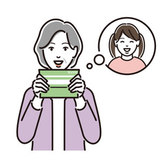 通帳を見て孫を思い浮かべるシニア女性
