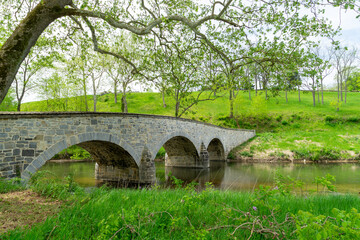 old stone curved bridge over a small creek