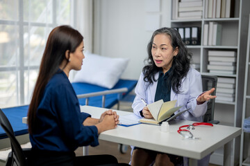 A woman is sitting at a desk with a doctor