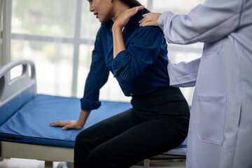 A woman is sitting on a bed with a doctor standing behind her