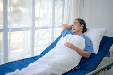A woman in a hospital bed is laying down with her head on a pillow