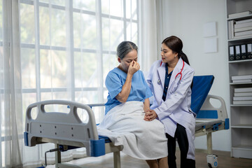 A woman in a hospital bed is crying while a doctor sits beside her