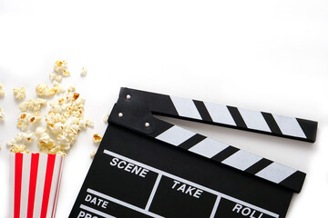 Clapperboard or movie slate black color with popcorn on white background. Cinema industry, video...