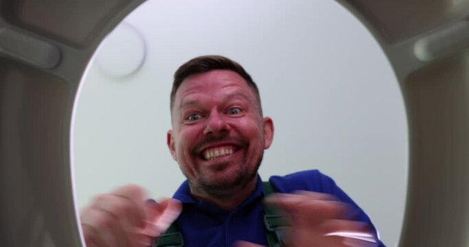 Joyful happy man finds socks in toilet. Plumber takes socks out of toilet