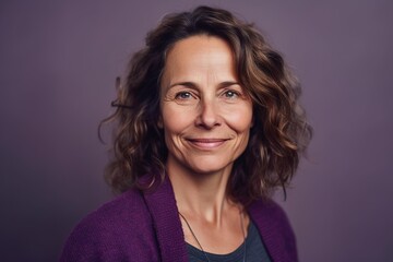 Fototapeta premium A woman with curly hair and a purple sweater is smiling