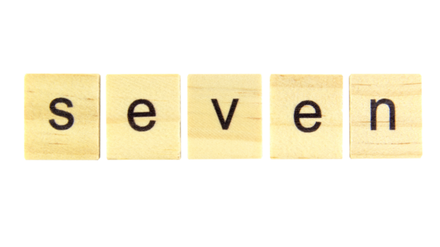 Short word english letter with text "seven" on a small wooden cubes block isolated on white background.