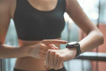 Close-up image of woman checking her smartwatch and counting calories burned during a workout...