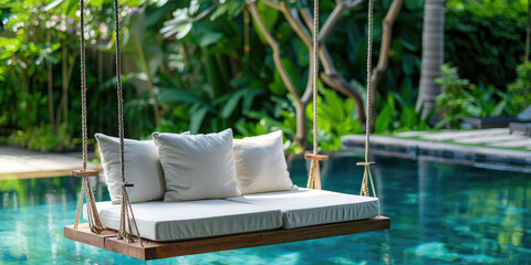 Close-up Minimal Beautiful Swing sofa on the Swimming pool water on outdoor beach in tropical hotel.