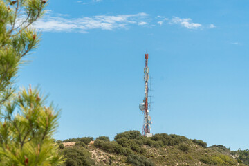 Communications tower on a mountain, signal repeater, sunny morning day.