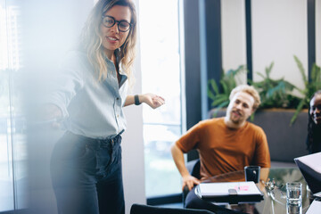 Business woman giving a visual presentation in front of her colleagues