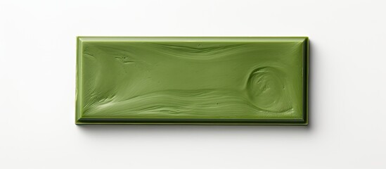 Top view of a delectable matcha chocolate bar neatly wrapped in foil placed on a white background with copy space for text