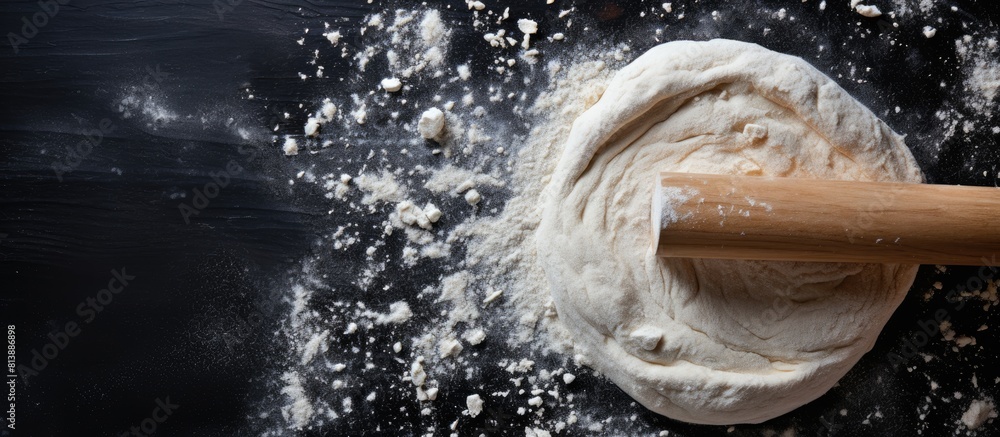 Poster top view close up of a rolling pin on a dark background with flour scattered around perfect image fo