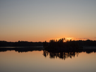 island on a forest lake at sunset