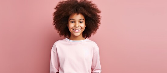Excited girl with an afro hairdo poses in casual outfit for a studio shot She radiates youth beauty and fashion making it an ideal image for sales and advertising purposes The pink background provide - Powered by Adobe
