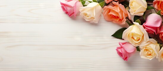 A top view copy space image of a bouquet of small roses arranged on a white wooden background