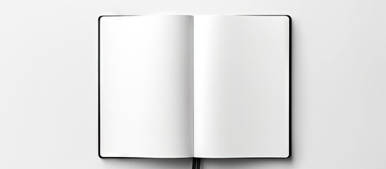 A top down view of a blank spiral bound sketchbook with an open page photographed against a white background The black and white minimalist design allows for ample copy space