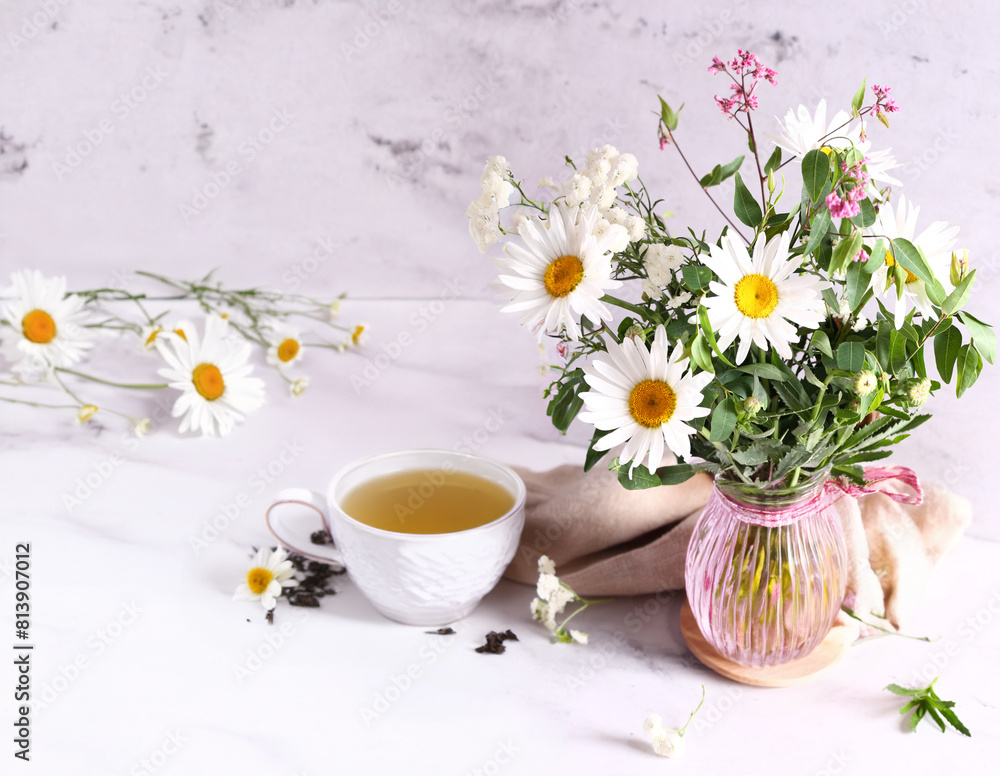 Sticker cup of herbal tea and a bouquet of chamomile flowers