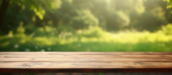 Fototapeta premium A wooden table with no items on it set against a blurred green background providing ample space for adding images or text