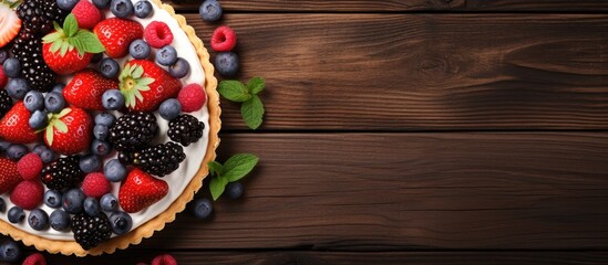 Top view of a tart adorned with fresh berries and cookies presented on a wooden background with...