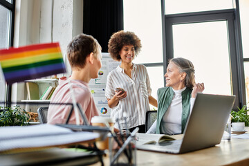 Jolly diverse businesswomen discussing ideas at desk in modern office.