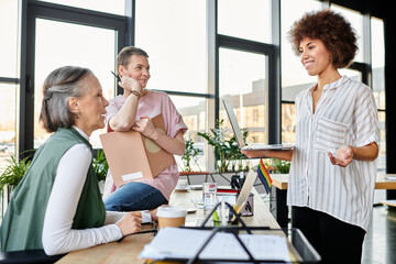 Fototapeta premium Hardworking, diverse women gathered around a table, collaborating in an office setting.