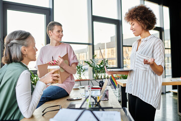 A diverse group of hardworking busnesswomen engaging in conversation around a table.