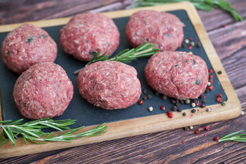 Beef raw meatballs on wooden background 