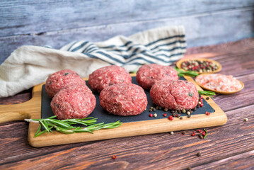 Beef raw meatballs on wooden background 