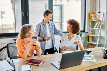 Group of diverse, hardworking women discussing strategy at a wooden table.