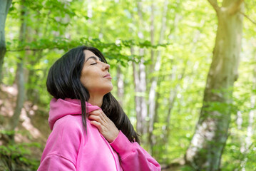 Relaxed woman breathing fresh air in a green spring  forest