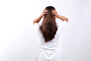 Back view of shocked young asian woman with hands on head. Isolated on white background