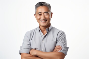 Portrait of a grinning asian man in his 50s with arms crossed in white background