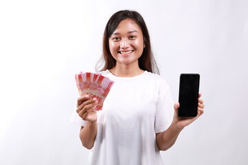 Young Asian Woman showing mobile phone screen and cash, money, concept of micro credit and bank...