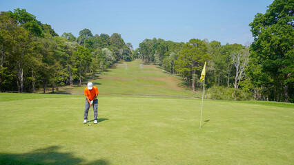 Obraz premium Golfer are playing game golf and hitting go on green grass mountain background.