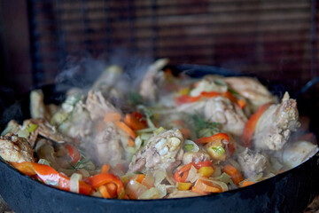 Pollo al disco with vegetables cooked in an old plow disk, typical argentine food.
