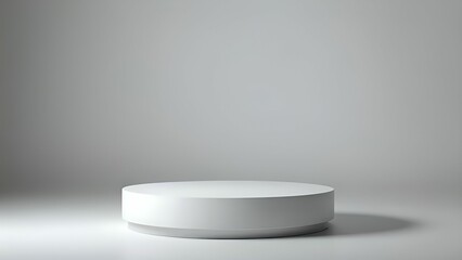 A white circular object on a grey surface with a shadow