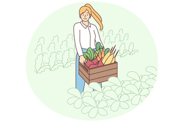 Smiling woman with box of vegetables