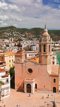 Aerial view of Sitges coastal town and the Iglesia de San Bartolome y Santa Tecla church on a sunny day in Sitges, Catalonia, Spain