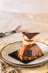 Glazed chocolate tartlet with topping of macaron and chocolate