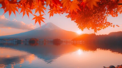 A serene view of Mount Fuji framed by vibrant red autumn leaves, with the mountain's reflection on...