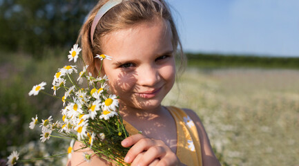 Child girl in a meadow with bouquet of daisies in summer. Earth Day. World Environment Day. world...