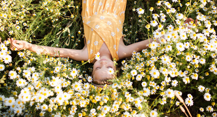 Child girl  lies in a meadow with a daisies in summer. Earth Day. World Environment Day. world...