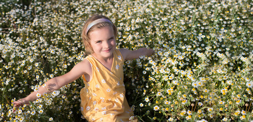 Child girl have fun  in a meadow with of daisies in summer. Earth Day. World Environment Day. world...