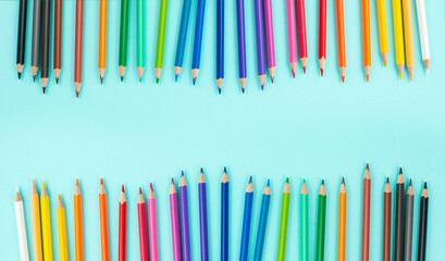 Color pencils collection in a row, back to school, drawing supplies, blue background with copy space