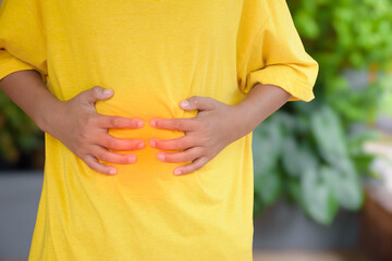 Asian man hands touching stomach due to abdominal pain cause is from abdominal pain and gastritis...