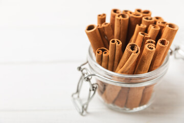Cinnamon sticks on a textured wooden background. Cinnamon roll. Spicy spice for baking, desserts and drinks. Fragrant ground cinnamon. cinnamon powder Close-up. Place for text. copy space