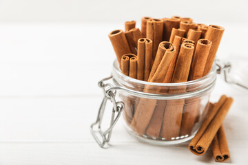 Cinnamon sticks on a textured wooden background. Cinnamon roll. Spicy spice for baking, desserts and drinks. Fragrant ground cinnamon. cinnamon powder Close-up. Place for text. copy space