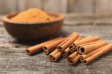 Cinnamon sticks on a textured wooden background. Cinnamon roll. Spicy spice for baking, desserts...